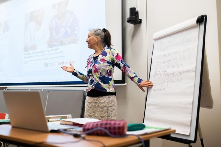 Een docent geeft les over de computer